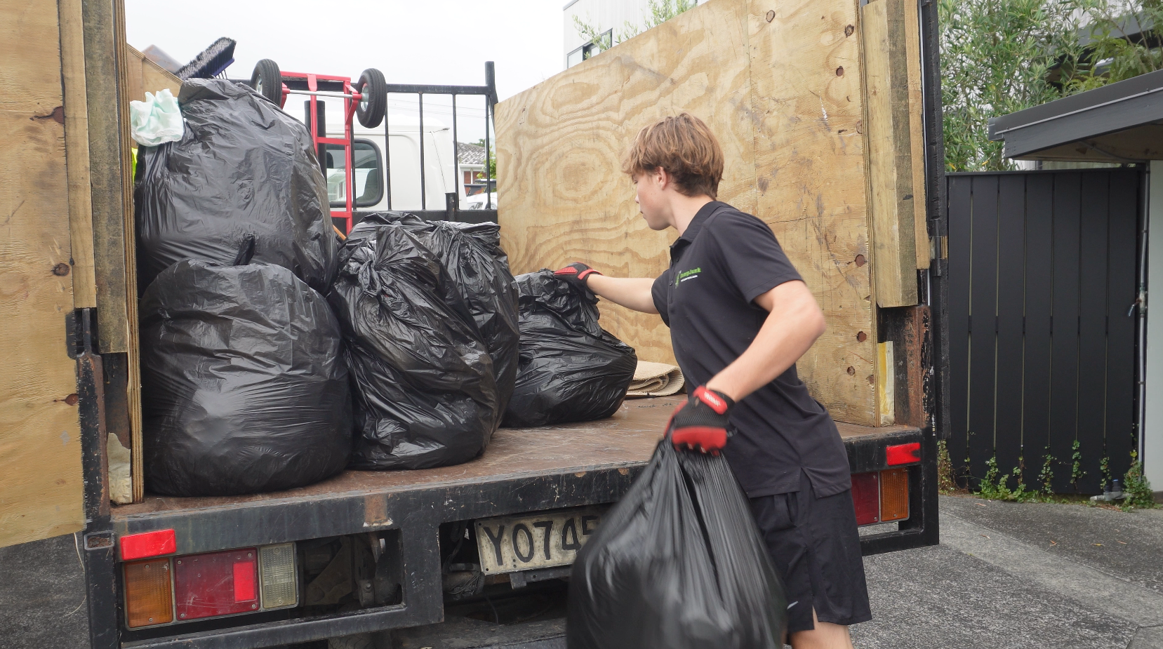 DumpJunk team loading rubbish bags onto truck in Red Beach